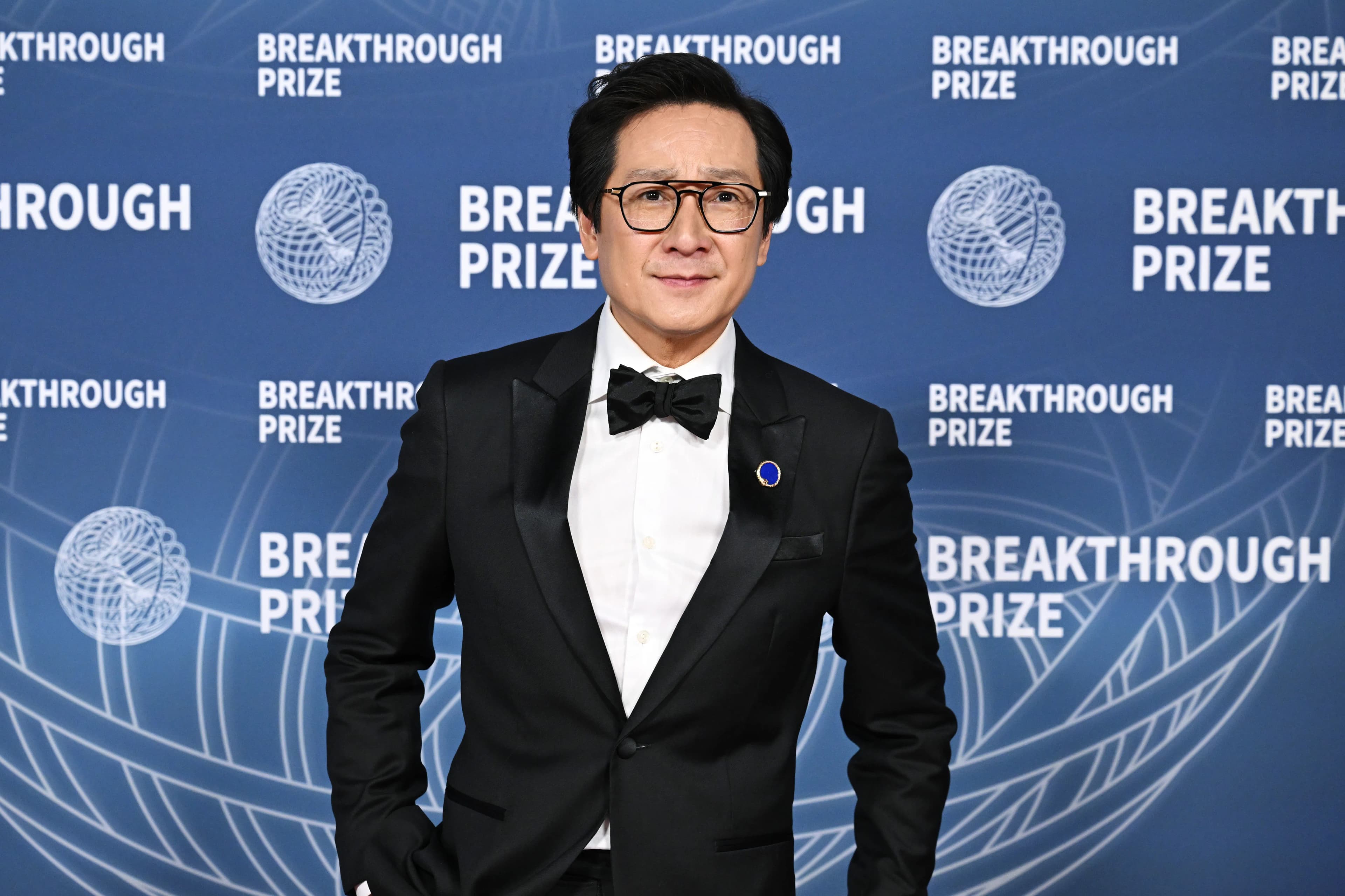 Ke Huy Quan smiling at a public event, promotional image tied to his memoir Never Say Die.