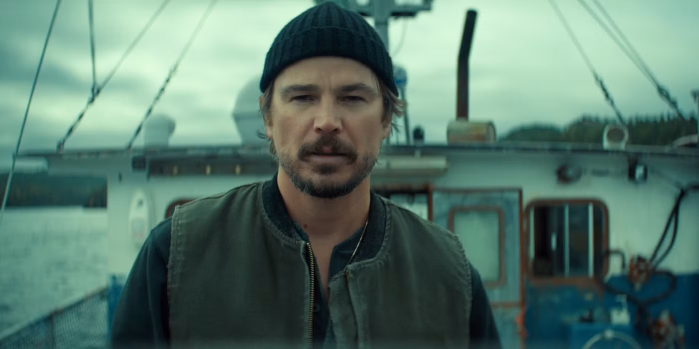 Josh Hartnett as Calvin Penney standing on a rocky shore in Newfoundland, looking out at a stormy sea.