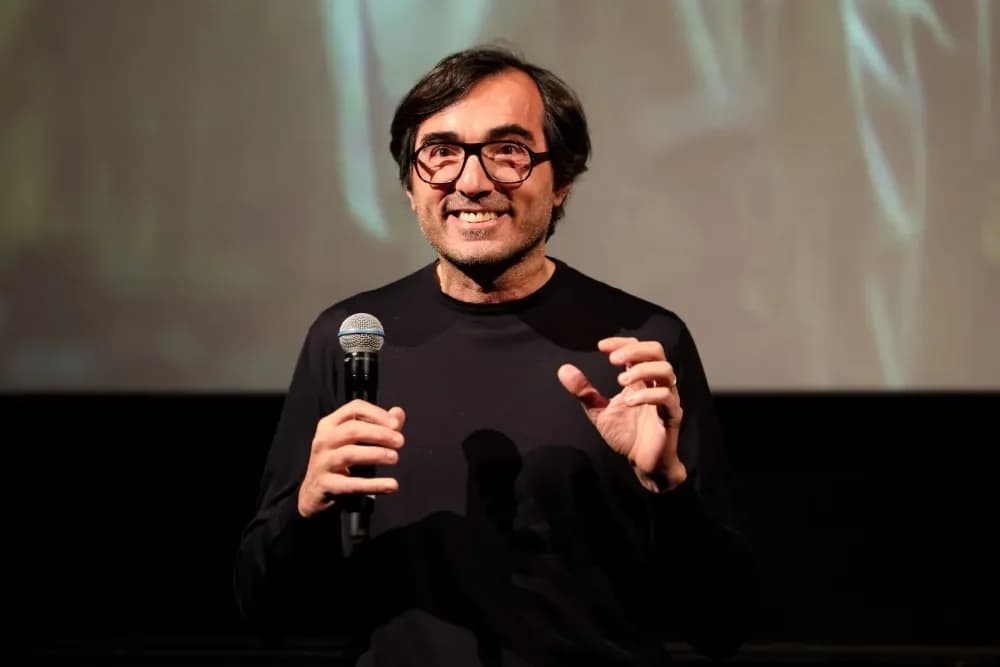 Efe Cakarel speaking on stage at the Zurich Summit with a backdrop showing the ‘Primetime’ poster