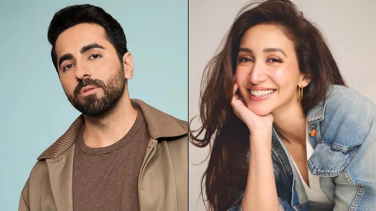 Ayushmann Khurrana and Shreyaa Chaudhry standing together on a film set, smiling at the camera.
