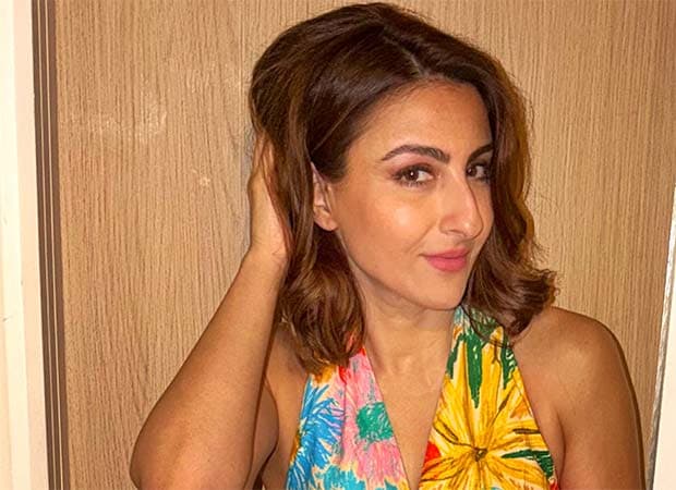 Soha Ali Khan walking along a Mumbai street past a broken manhole cover and ongoing roadwork.