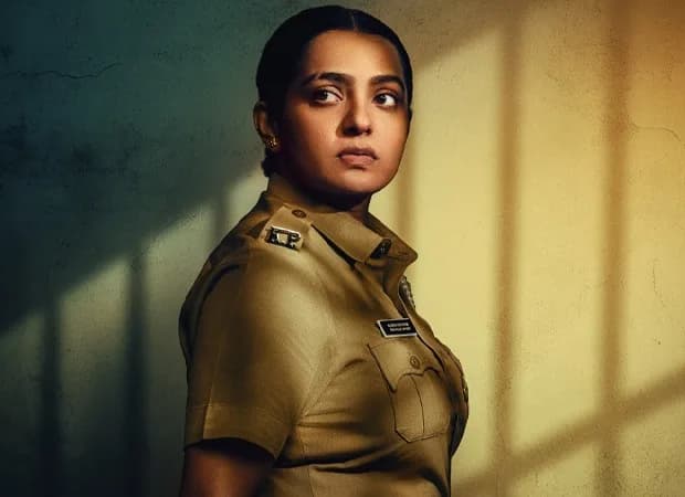 Parvathy Thiruvothu in a police uniform, standing in a dimly lit corridor, looking thoughtful.
