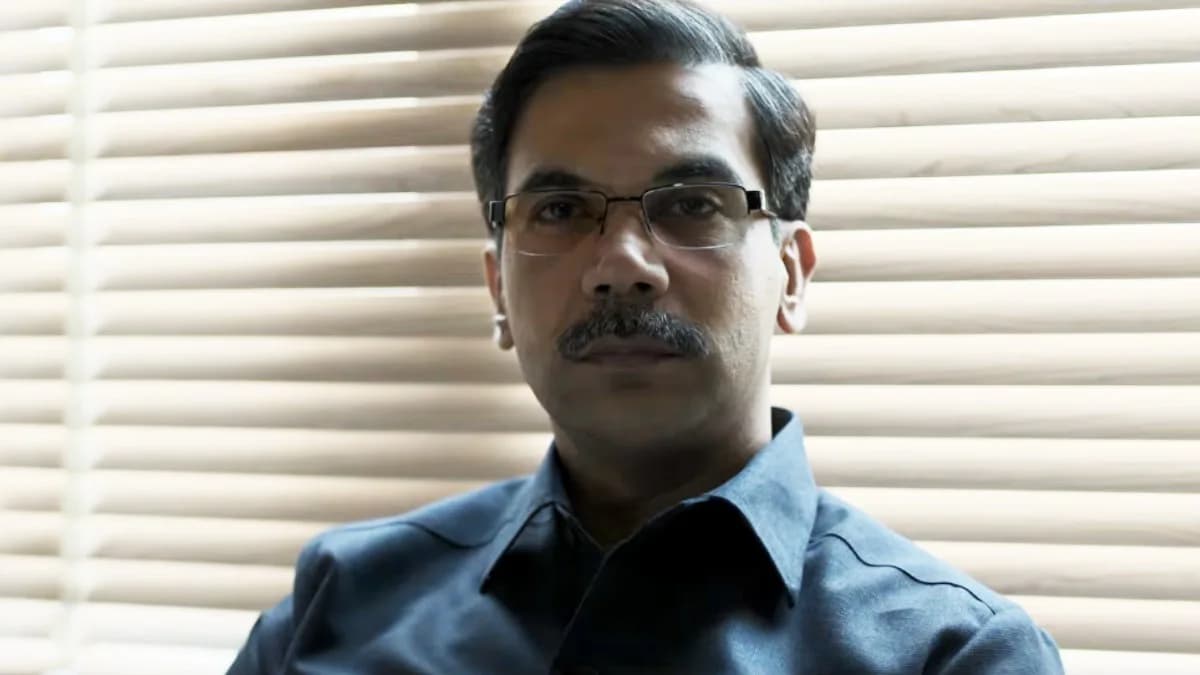 Rajkummar Rao in a courtroom scene, looking solemn, surrounded by documents and muted light.