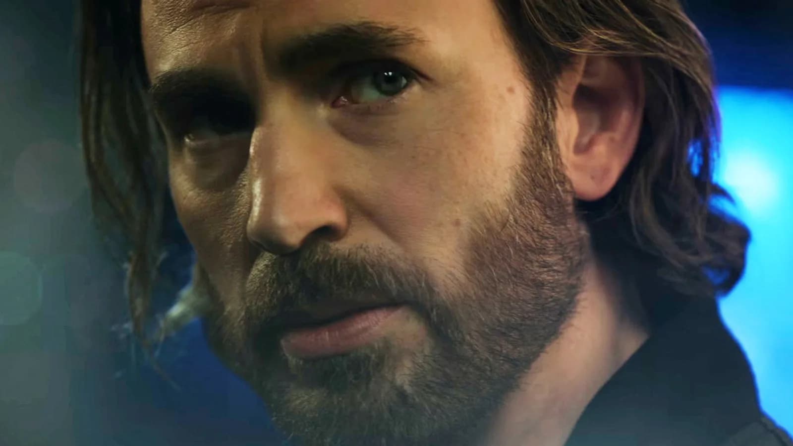 Chris Evans as Steve Rogers in a dark suit, standing next to Ben Grimm in the Watchtower. His face is slightly blurred, as if digitally altered.