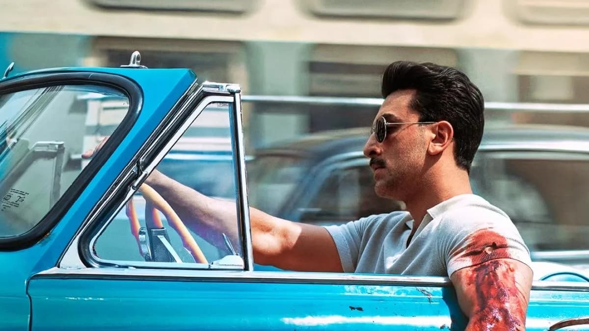 Ranbir Kapoor in a vintage look with a bloodied arm, driving a blue convertible in the first poster for Sanjay Leela Bhansali's Love & War