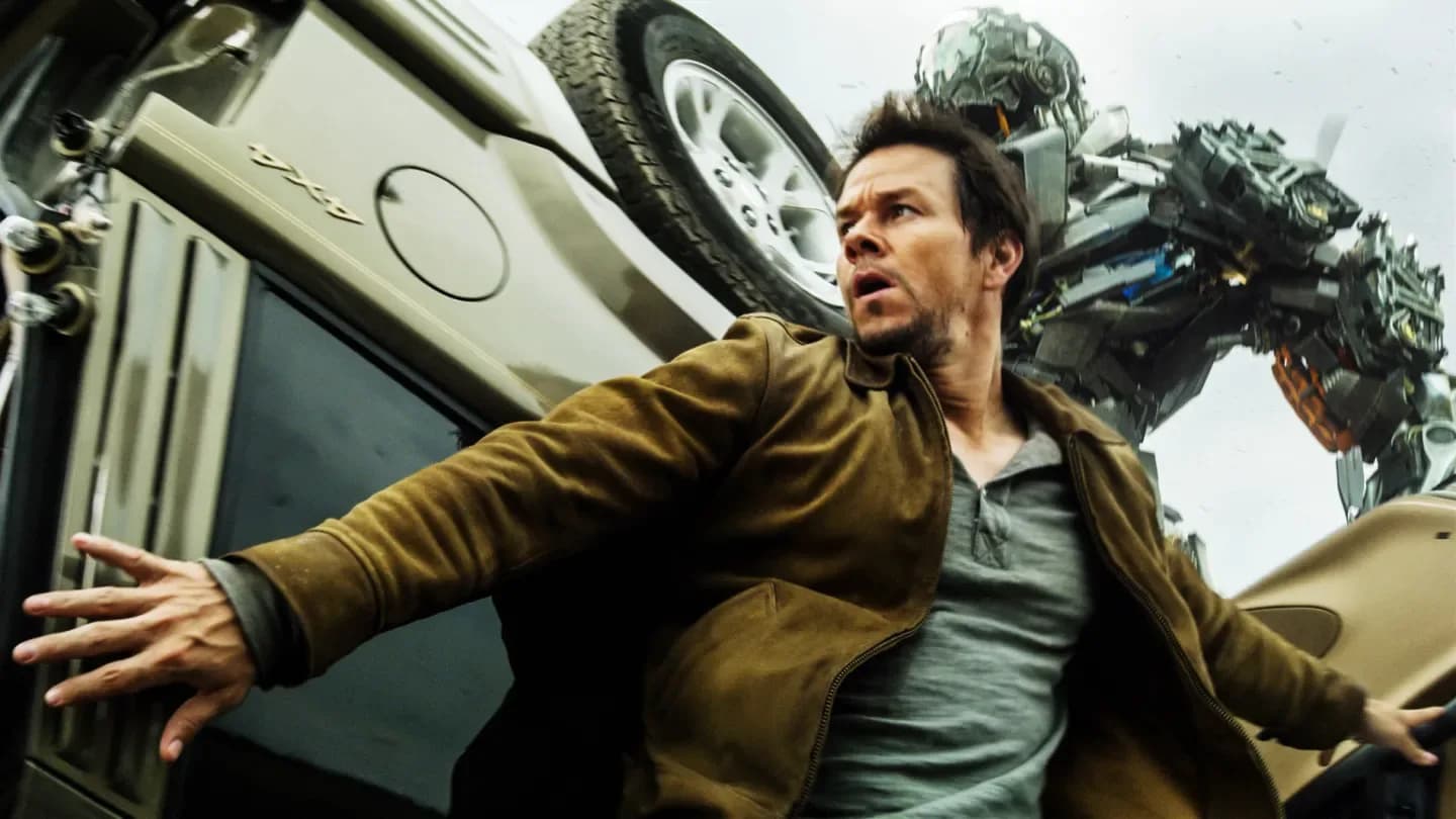A still from the 2007 Transformers film showing Optimus Prime and Megatron in battle, with Steven Spielberg's name superimposed over the image.
