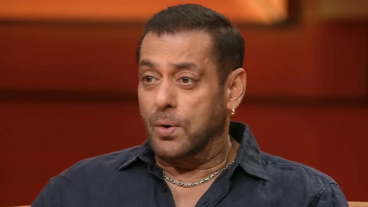 Salman Khan sitting on a couch in Koffee With Karan, smiling at Karan Johar