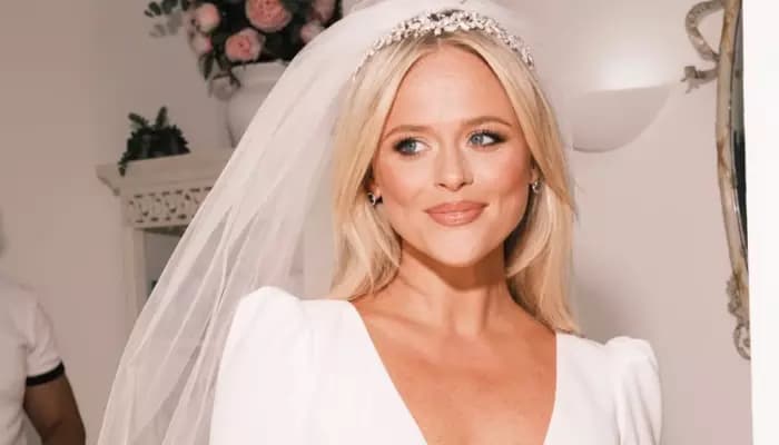 Emily Atack and Dr Alistair Garner posing near a red Cadillac after their wedding ceremony in Mojacar, Spain.