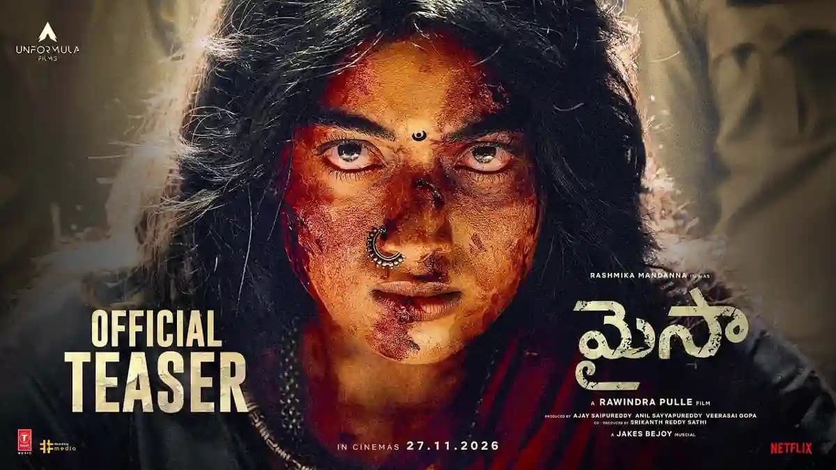 Rashmika Mandanna in warrior armor from Mysaa teaser, brandishing a sword amid a forest backdrop with mist and water.