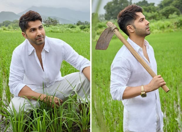 Varun Dhawan standing on farmland during a visit to his newly acquired property.