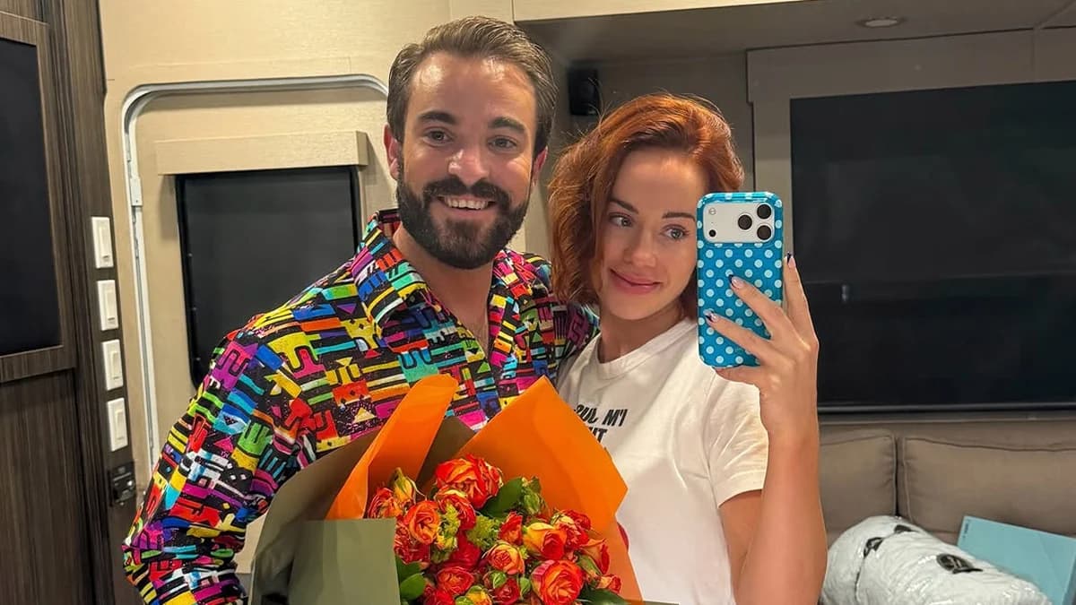 Whitney Leavitt and Conner Leavitt pose together, with Conner holding a large floral bouquet after his DWTS elimination.