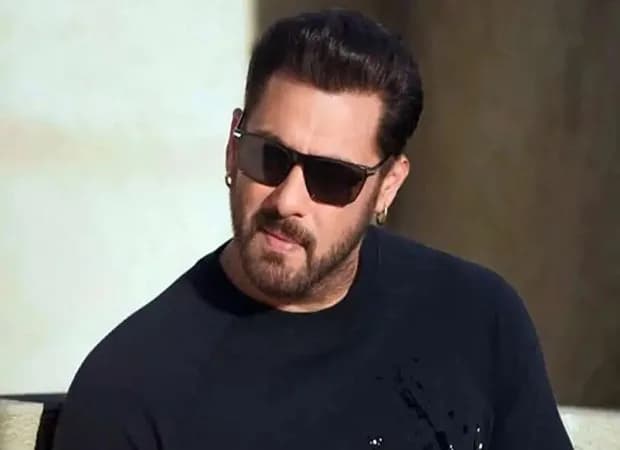 Salman Khan standing in front of a chalkboard, writing the Hindi alphabet