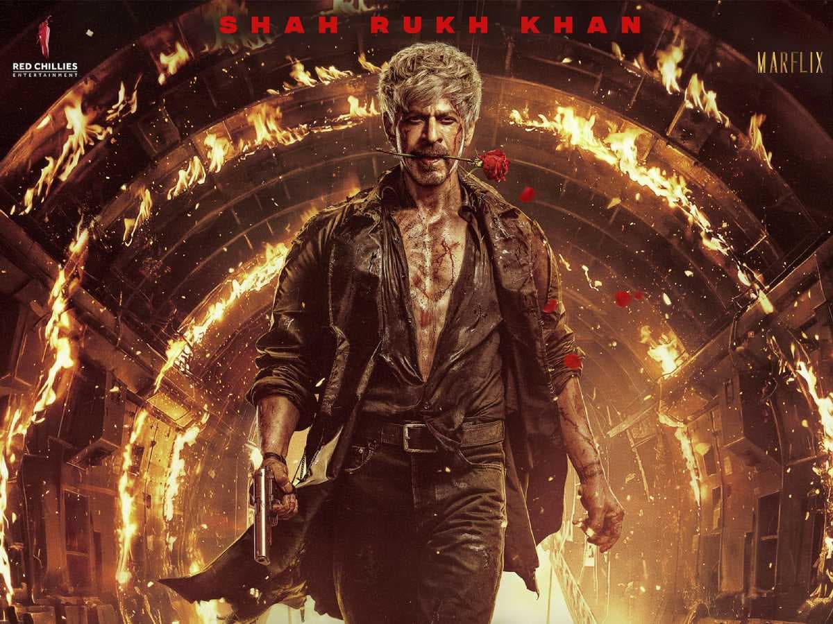Shah Rukh Khan in a dark suit, standing against a city skyline, looking intense